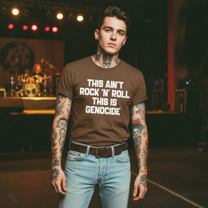 Brown t-shirt with text 'THIS AIN'T ROCK 'N' ROLL THIS IS GENOCIDE' in a rustic setting with a chicken and bicycle.