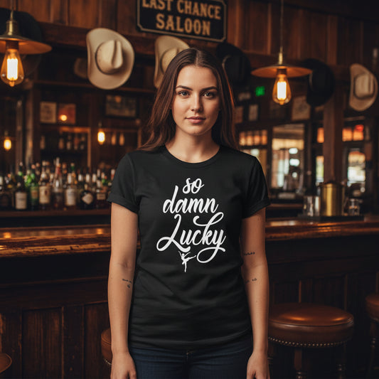 Black t-shirt with 'so damn lucky' text in white against a rustic background