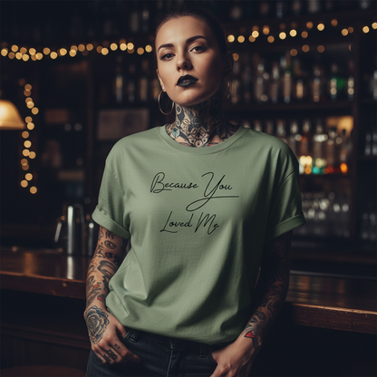 Green t-shirt with 'Because You Loved Me' text on a white background