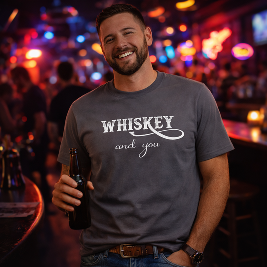 Man wearing a 'Whiskey and you' shirt holding a bottle in a bar setting