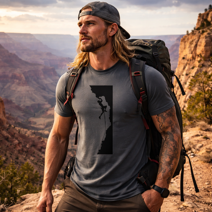 Man with a backpack standing in a desert landscape with mountains in the background