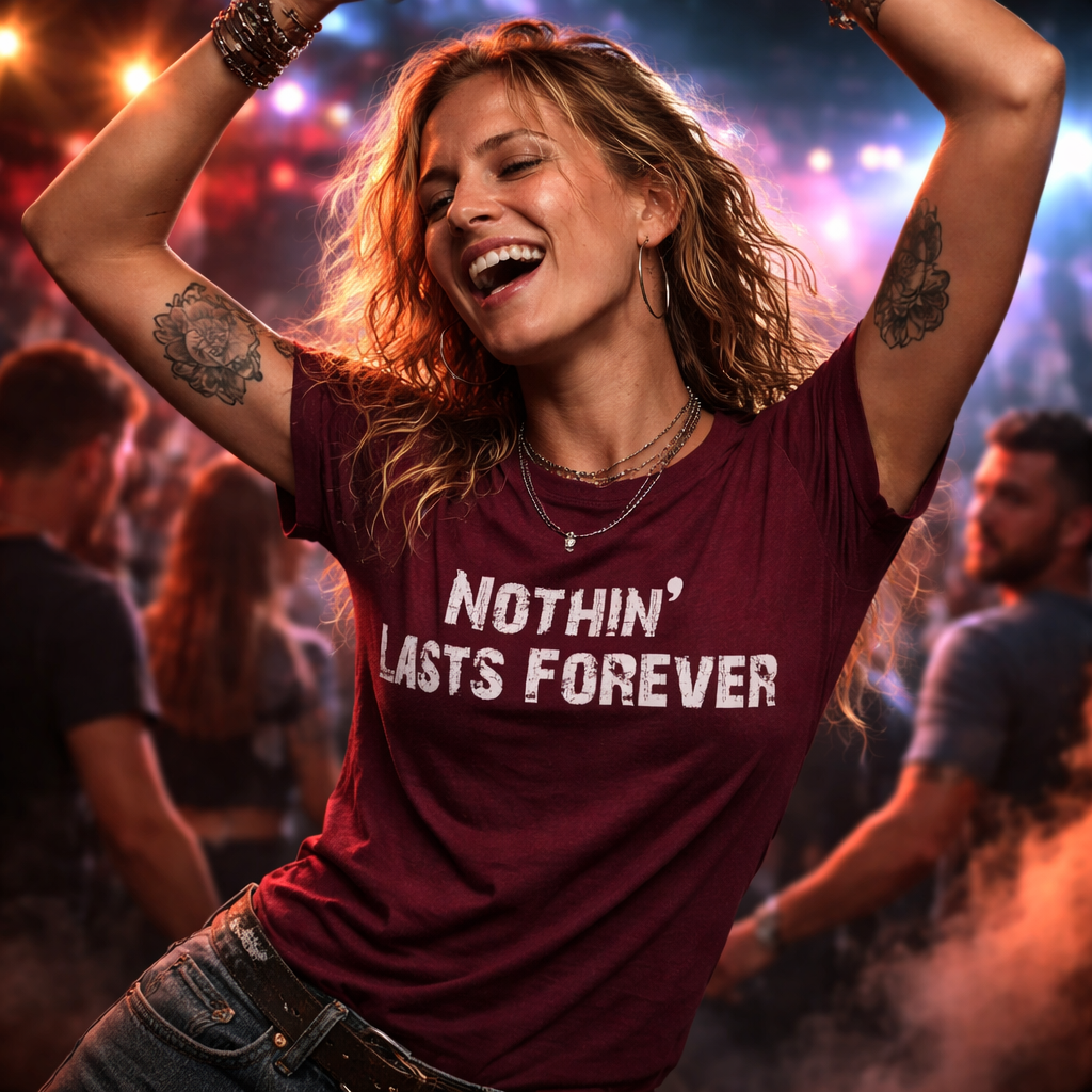 Woman in a maroon t-shirt with 'Nothin' Lasts Forever' text at a concert.