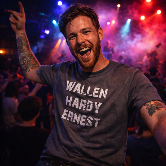 Man wearing a t-shirt with 'WALLEN HARDY ERNEST' at a concert with colorful lights.