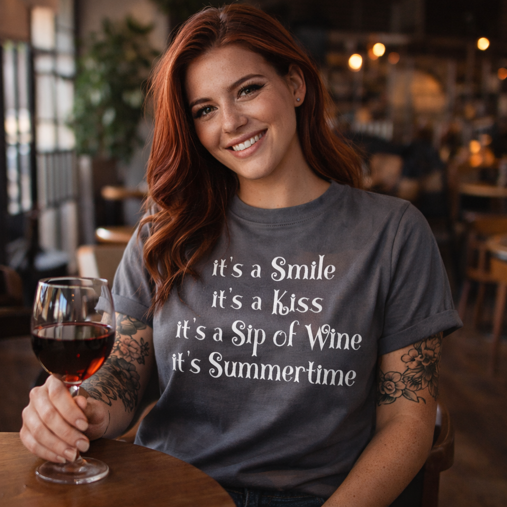 Woman in a casual setting holding a glass of wine, wearing a t-shirt with a summertime quote.